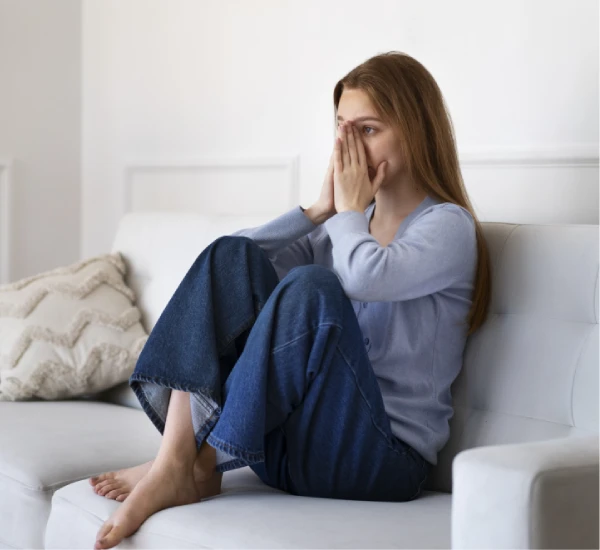 woman sitting depressed on sofa in need of ketamine treatment nyc